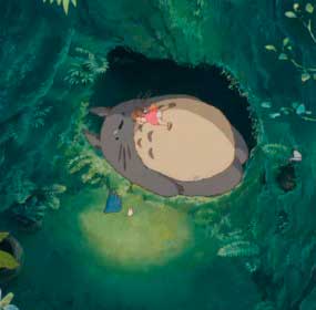 Imagem que mostra uma cena do longa 'Meu amigo Totoro', onde mostra Mei Kusakabe dormindo em cima de Totoro